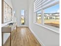 Hallway featuring wood floors, modern console table, and large windows with bright natural light at 15750 Vetta Dr, Montverde, FL 34756