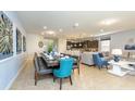 Open-concept dining area with long table set, flowing into a kitchen and living room at 1876 Nice Ct, Kissimmee, FL 34747