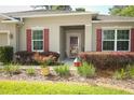 Inviting front entrance with red shutters and a well-maintained landscape, creating a warm curb appeal at 30413 Plymouth Creek Cir, Sorrento, FL 32776