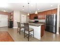 Modern kitchen features a granite island, stainless steel appliances, and stylish pendant lighting at 30413 Plymouth Creek Cir, Sorrento, FL 32776
