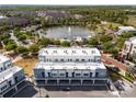 Gorgeous aerial view shows the townhome community and its proximity to a scenic pond and surrounding lush green landscape at 336 Center Lake Ln # A-2, Oviedo, FL 32765