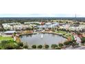 Aerial view featuring a pond, lush landscaping, and colorful townhomes highlights the desirable community at 336 Center Lake Ln # A-2, Oviedo, FL 32765