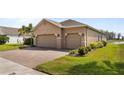 A spacious three-car garage featuring a brick driveway and verdant green landscaping at 3936 Parkhouse Dr, Orlando, FL 32824