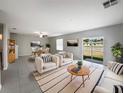 Bright living room featuring neutral tones, large windows, and modern furniture with a dining area at 4346 Trotters Way, Lakeland, FL 33801