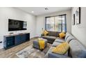 Comfortable living room with a gray sectional, TV, and wood-look flooring at 4461 Summer Flowers Pl, Kissimmee, FL 34746