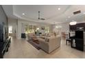 Spacious living room with tile flooring, a ceiling fan, and sliding glass doors to the screened in porch at 5007 Belted Kingfisher Dr, Oxford, FL 34484