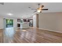 Open-concept living room and kitchen area with wood-style flooring and stainless appliances at 57 Pine Trace Crse, Ocala, FL 34472