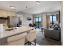 Bright condo featuring a small kitchen, a dining room set, a sofa, and a view of the lake at 6165 Carrier Dr # 2001, Orlando, FL 32819