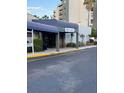 Building entrance with guest registration sign, covered canopy, and well-maintained landscaping at 6165 Carrier Dr # 3104, Orlando, FL 32819