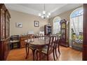 Formal dining room with vintage furniture, including a grandfather clock, china cabinet, and glass table at 625 Waterland Ct, Orlando, FL 32828