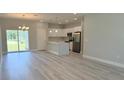 Open-concept living room flows into a modern kitchen with stainless steel appliances at 6345 Sw 155Th Pl, Ocala, FL 34473