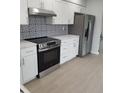 Bright, newly renovated kitchen with stainless steel appliances and tiled backsplash at 769 Avenue Q Se, Winter Haven, FL 33880