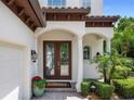 Elegant front entryway with leaded glass double doors and manicured landscaping at 8161 Via Rosa, Orlando, FL 32836