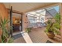 Enclosed brick patio with seating, potted plants, and skylight, as seen from the home's open entryway at 908 Hillary Ct # 15, Orlando, FL 32804