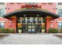 Inviting entrance to Uptown Place features glass doors, planters, and overhead lighting at 911 N Orange Ave # 541, Orlando, FL 32801