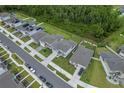 An aerial view of a neighborhood showcasing houses with well-kept lawns and tree-lined streets at 9763 Brown Burrow St, Orlando, FL 32829