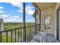 A private balcony with seating offers a serene view of the surrounding greenery and distant buildings at 14501 Grove Resort Ave # 3735, Winter Garden, FL 34787