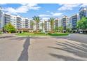 Elegant building entrance featuring palm trees and a well-manicured roundabout for convenient access to the condos at 14501 Grove Resort Ave # 3735, Winter Garden, FL 34787