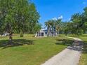 Charming single-story home with lush green lawn, mature trees, and a circular driveway at 18618 Lake Pickett Rd, Orlando, FL 32820