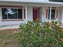 Inviting front porch with decorative brick accents, a red door, and lush landscaping at 217 Longleaf Ct, Orlando, FL 32835