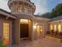 Elegant entryway featuring a turret, double doors, transom windows, and a brick paver courtyard at 2108 Northumbria Dr, Sanford, FL 32771