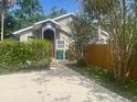 Exterior view of the home with a well-maintained lawn, mature trees, and a fenced backyard at 250 E 20Th Ave, Mount Dora, FL 32757