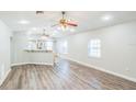 Spacious living room with hardwood flooring, a ceiling fan, and large windows for plenty of natural light at 250 E 20Th Ave, Mount Dora, FL 32757
