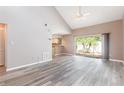Bright and airy living room featuring high ceilings, wood floors, and sliding door access to the outdoors at 4060 E Maryland Pl, Casselberry, FL 32707