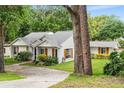 Charming single-story home with lush landscaping and a well-manicured lawn at 407 Forest Rd, Mount Dora, FL 32757