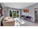 Bright living room featuring large window, terrazzo flooring, and stylish contemporary furnishings at 112 E Coleman Cir, Sanford, FL 32773