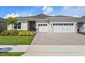 Charming single-story home with a three-car garage, paver driveway, and beautifully landscaped front yard at 13133 Sunny Retreat Ln, Winter Garden, FL 34787