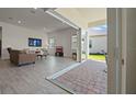 Open living room with tile flooring, comfortable seating, and seamless access to the outdoor patio at 13133 Sunny Retreat Ln, Winter Garden, FL 34787