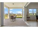 Covered patio with outdoor dining set and pavers, offering scenic backyard views at 13133 Sunny Retreat Ln, Winter Garden, FL 34787