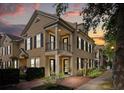 Charming two-story townhome featuring black shutters, a balcony, and well-maintained landscaping at dusk at 1316 Lake Baldwin Ln, Orlando, FL 32814