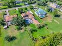 An aerial view of a home with a screened-in pool, green lawns and mature trees at 14343 Tilden Rd, Winter Garden, FL 34787