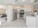 Bright kitchen featuring stainless steel appliances, white cabinetry, and a convenient breakfast bar at 14433 Huntingfield Dr, Orlando, FL 32824