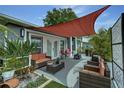 Relaxing outdoor patio with comfortable seating, a shade sail, and views of the landscaped yard at 1448 Lambert St, Deltona, FL 32725