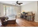 Comfortable living room with wood floors, study area, and sliding doors leading to the exterior at 1475 Lake Shadow Cir # 6205, Maitland, FL 32751
