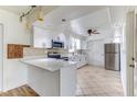 Spacious kitchen features white cabinets, stainless appliances, and a convenient breakfast bar at 1624 Bel Air Ave, Orlando, FL 32812