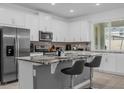 Bright kitchen featuring granite countertops, stainless steel appliances, and bar stool seating at 1644 Tropical Palms Cir, Kissimmee, FL 34747