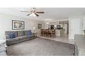 Open-concept living area with ceiling fan, gray sofa, and adjacent dining space at 2047 Royal Bay Blvd # 21, Kissimmee, FL 34746