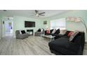 Bright living room featuring stylish decor, a ceiling fan, and large windows for ample natural light at 3 Poinsettia Dr, Debary, FL 32713