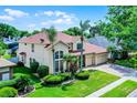 Spacious two-story home featuring lush landscaping, a three-car garage, and a red tile roof at 3033 Zaharias Dr, Orlando, FL 32837