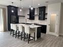 Kitchen island with seating complements the stainless appliances, dark cabinets, and modern design at 3764 Rachel St, Apopka, FL 32703