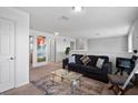 Bright loft area featuring a comfortable black sofa, plush throw pillows, and a glass coffee table at 4951 Alita Ter, St Cloud, FL 34769
