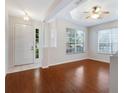 Bright living room featuring hardwood floors, a modern ceiling fan, and large windows for natural light at 5044 Wise Bird Dr, Windermere, FL 34786
