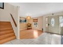 Bright foyer showcasing tile and wood flooring, an elegant chandelier, and staircase at 5051 Silver Thistle Ln, St Cloud, FL 34772