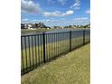 Picturesque lake view from the backyard, enhanced by an elegant black metal fence at 5406 Crepe Myrtle Cir, Kissimmee, FL 34758