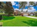 Two story brick home with manicured lawn and an attached two car garage on a sunny day at 5479 Baytowne Pl, Oviedo, FL 32765