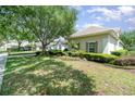 Exterior view of a home featuring manicured lawn and mature landscaping, creating a welcoming and picturesque setting at 6125 Foxfield Ct, Windermere, FL 34786